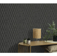 Nahaufnahme einer Wand mit einer strukturierten Tapete, einem Tisch mit einer Lampe und Pflanzen