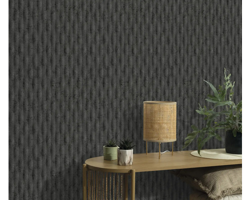 Nahaufnahme einer Wand mit einer strukturierten Tapete, einem Tisch mit einer Lampe und Pflanzen