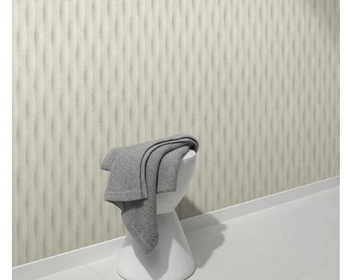 Szene mit dreidimensionaler Wandgestaltung, weißem Hocker und grauem Handtuch