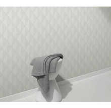 Helle Wand mit geometrischem Muster und Hocker mit Decke