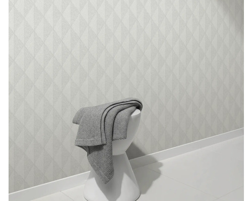 Helle Wand mit geometrischem Muster und Hocker mit Decke