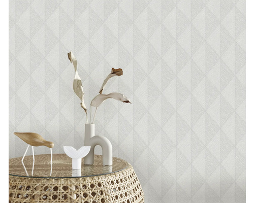 Nahaufnahme einer strukturierten Tapete mit geometrischem Muster und Dekorationsgegenständen auf einem Beistelltisch