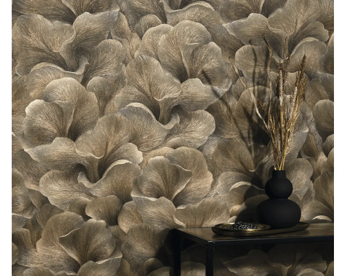 Detailaufnahme einer Wand mit floral gemusterter Tapete und einem kleinen Tisch mit Dekoration