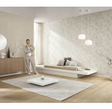 Heller Wohnraum mit gemusterten Tapeten, niedrigem Sofa, Teppich und Dekoration