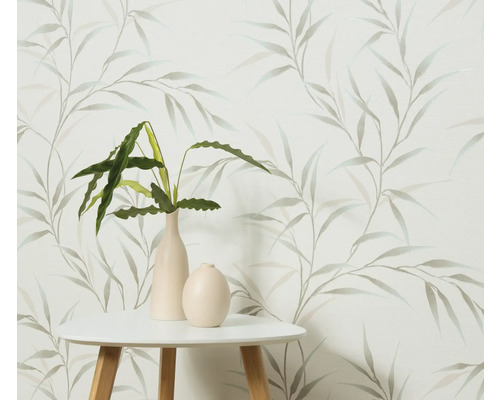 Dekorative Tapete mit Blattmuster, kombiniert mit einem Tisch und Zimmerpflanzen in Vasen.