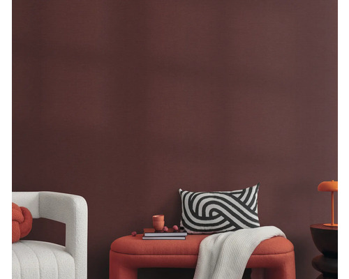 Wohnzimmer mit Sitzbank, Kissen und Dekoration vor einer Wand