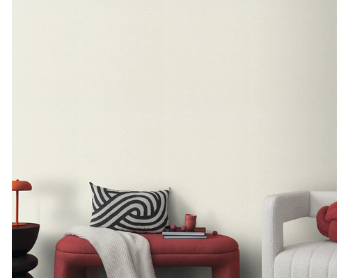 Wohnzimmer mit Bank, Kissen und Dekoration vor einer hellen Wand