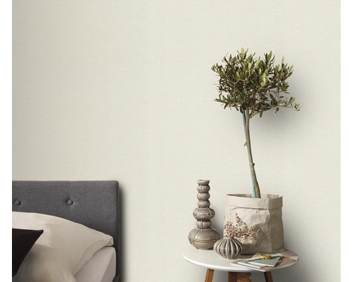 Schlafzimmer mit Bett, Beistelltisch und dekorativen Elementen wie einer Pflanze und Vasen