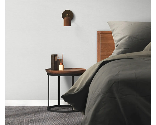 Schlafzimmer mit Bett, Nachttisch, Lampe und Duftspender