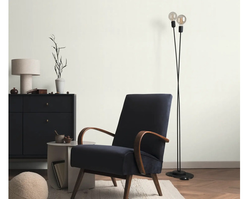 Wohnzimmer mit Sessel, Stehlampe und Kommode für eine gemütliche Atmosphäre.