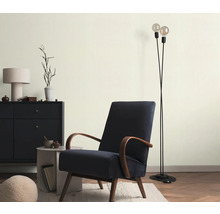 Wohnzimmer mit Sessel, Stehlampe und Kommode für ein stilvolles Ambiente