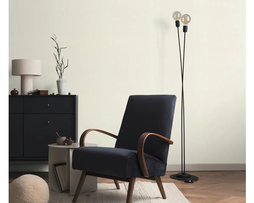 Wohnzimmer mit Sessel, Stehlampe und Kommode für ein stilvolles Ambiente