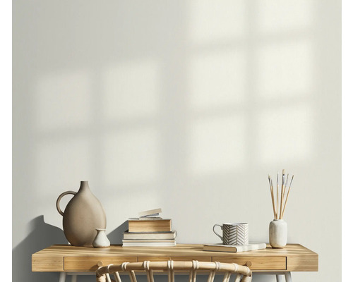 Helles Arbeitszimmer mit Schreibtisch, Bücherstapel, Vasen und einer Tasse