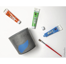 Betonpflanztopf mit Farbtuben und Pinsel