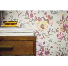 Detailansicht einer floral gemusterten Tapete neben einem Nachttisch