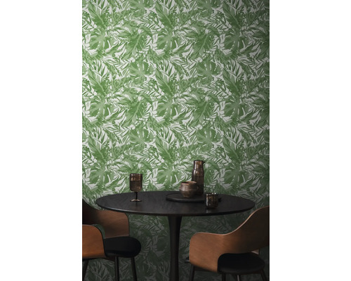 Esszimmer mit grüner Blättertapete, rundem Tisch und Stühlen