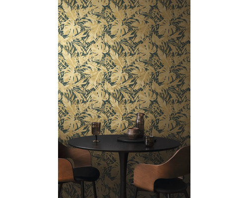 Ein Zimmer mit einer Blattmuster-Tapete, einem Esstisch und Stühlen.