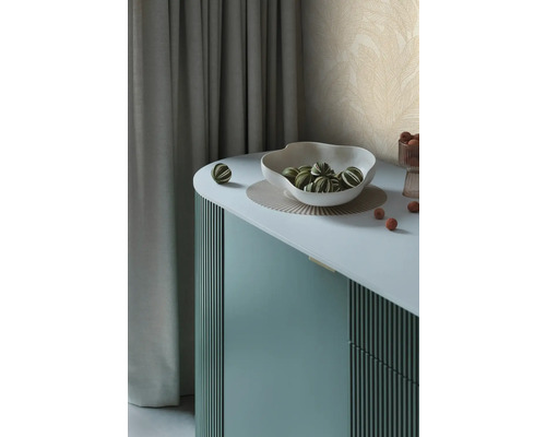 Dekorative Anrichte mit Schale und grün-gestreiften Kugeln auf einer Unterlage.