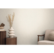 Heller Raum mit strukturierten Tapeten, dekoriert mit einer Vase und einem Sessel für eine wohnliche Atmosphäre.