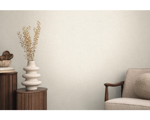 Heller Raum mit strukturierten Tapeten, dekoriert mit einer Vase und einem Sessel für eine wohnliche Atmosphäre.