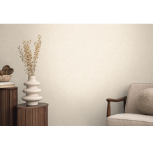 Wohnraum mit Textiltapete, Sessel, rundem Beistelltisch und Dekoration