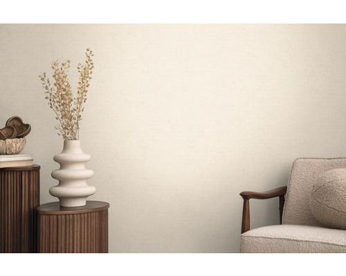 Wohnraum mit Textiltapete, Sessel, rundem Beistelltisch und Dekoration