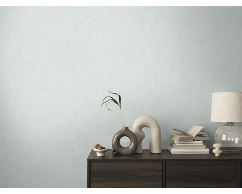 Wohnraum mit gemusterter Tapete und Kommode mit dekorativen Elementen.