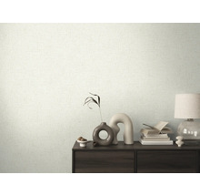 Wandgestaltung mit hell gemusterter Tapete und dunklem Holzschrank mit Dekorationen