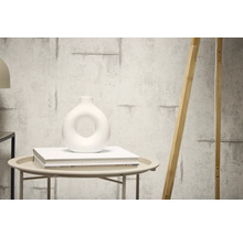 Dekorative Wand mit Zementstruktur und daran angelehnt ein Holzelement.