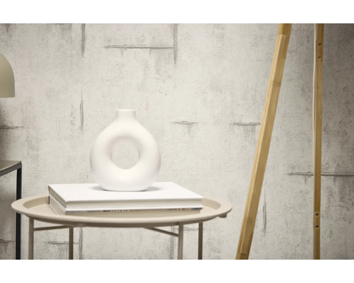 Dekorative Wand mit Zementstruktur und daran angelehnt ein Holzelement.