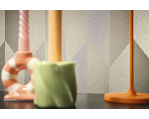 Nahaufnahme einer gemusterten Tapete mit geometrischen Formen im Hintergrund von drei Kerzenständern.