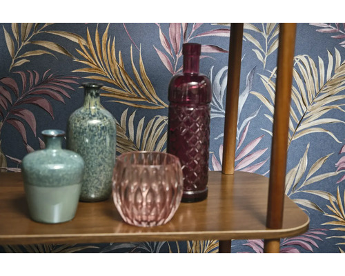 Dekorative Vasen und Glasobjekte auf einem Holzregal vor einer gemusterten Tapete