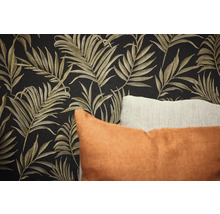 Nahaufnahme einer Wand mit Blättermuster-Tapete und Zierkissen