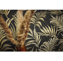 Nahaufnahme einer schwarzen Tapete mit goldenem Palmenblattmuster