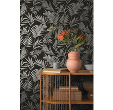 Dekorative Tapete mit Palmenblattmuster, kombiniert mit Regalelementen und Dekorationsgegenständen.