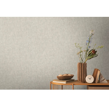 Nahaufnahme einer hellen Wand mit einer dezent gemusterten Tapete, die eine ruhige und einheitliche Textur erzeugt.