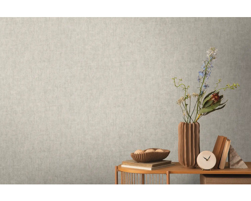 Nahaufnahme einer hellen Wand mit einer dezent gemusterten Tapete, die eine ruhige und einheitliche Textur erzeugt.