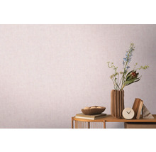 Dekoratives Stillleben mit Vase, Blumen und Büchern vor einer gemusterten Tapete