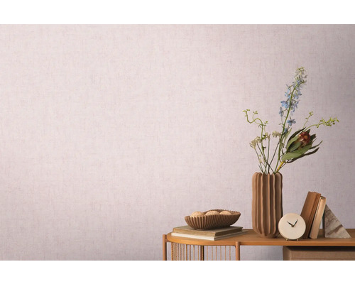 Dekoratives Stillleben mit Vase, Blumen und Büchern vor einer gemusterten Tapete