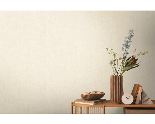 Dekoratives Stillleben mit Blumen, Vasen, Büchern und Uhr auf einem Tisch vor einer Wand