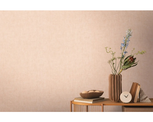 Dekorative Szene mit Vase, Blumen, Büchern und Accessoires auf einem Tisch vor einer Wand