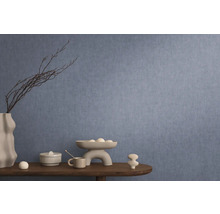 Dekoratives Interieur mit blauer Wandtapete, Tisch mit Dekorationen wie Vase, Schale und Keramikfiguren