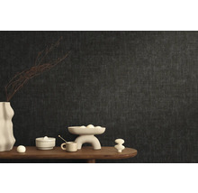 Stilvolle Raumgestaltung mit dunkler Vliestapete und dekorativen Elementen auf einem Holztisch.