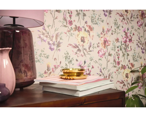 Wohnraumszene mit Blumentapete, Tischleuchte, Vasen, Büchern und Schale.