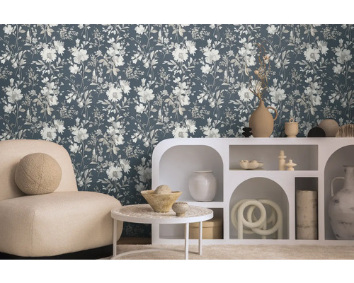 Wohnzimmer mit blumiger Tapete, Sessel und weißem Regal