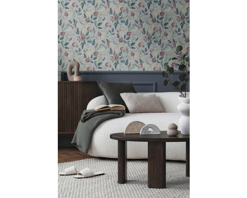 Wohnzimmer mit floral gemusterter Tapete, Sofa, Tisch und Dekorationsgegenständen für ein gemütliches Ambiente.