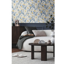 Wohnzimmer mit floraler Tapete, Sofa, Couchtisch und dekorativen Accessoires für ein gemütliches Ambiente.