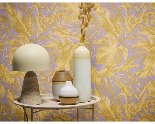 Dekoratives Stillleben mit Tischleuchte und Vasen vor einer Tapete mit Pflanzenmotiven.