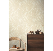 Ein Zimmer mit einer Wandtapete mit Blattmuster, einem Holzstuhl und einem dunklen Holzschrank.