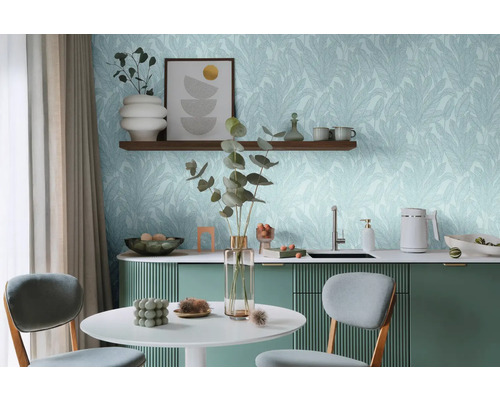 Heller Raum mit Tisch, Stühlen und Küchenzeile vor einer Wand mit Blättertapete.